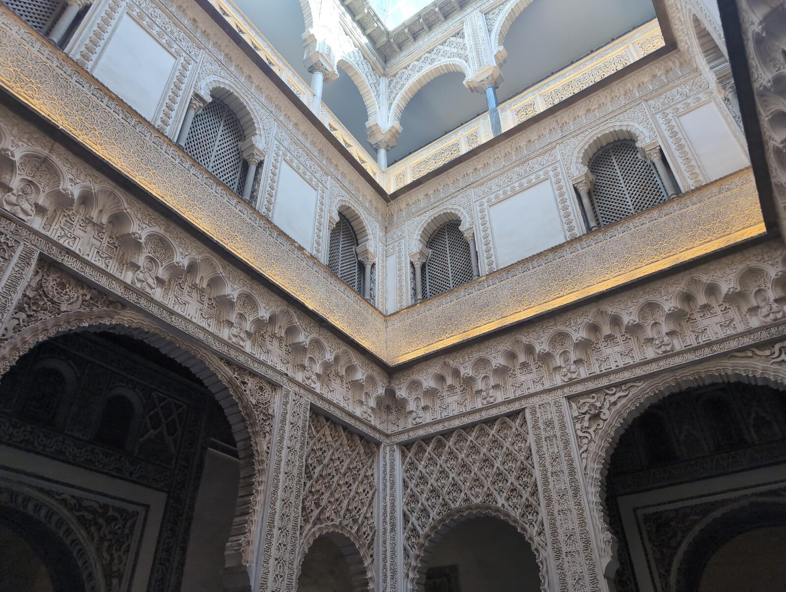 Carved arches and upper galleries around a courtyard at the Alcázar