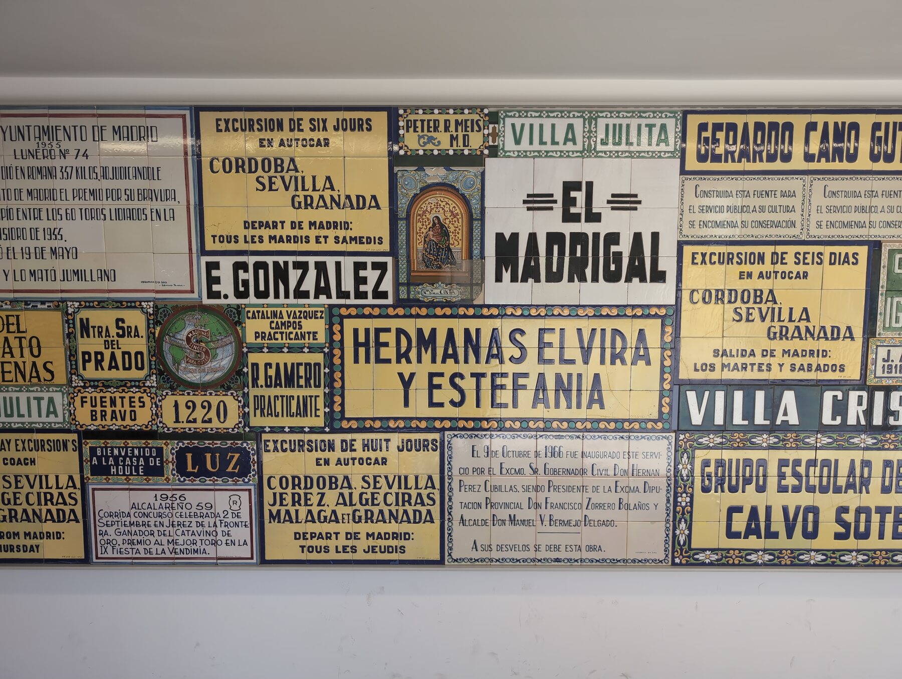 A wall of historic ceramic advertisements and public signs