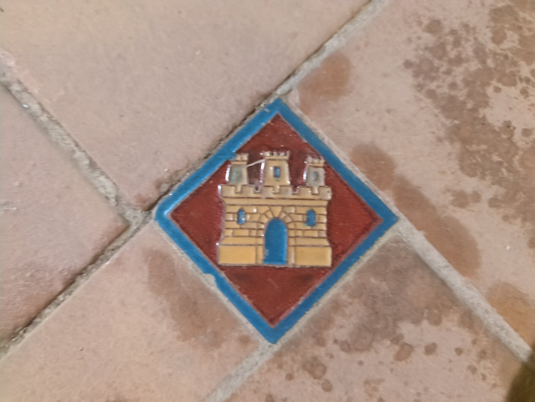 A small castle tile set into the floor at Plaza de España